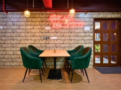 Green seating and neon sign inside The Divine Bite